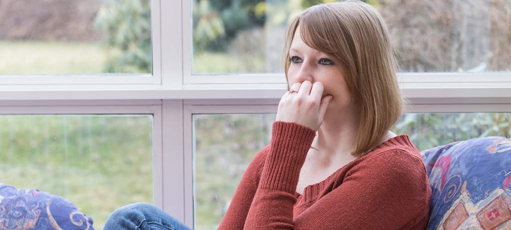 Picture of worried woman on the couch