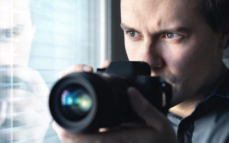 Private Investigator Holding a Camera and Looking from the Window
