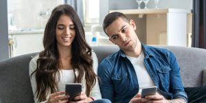 Emotional affair of cheating wife texting while husband is looking