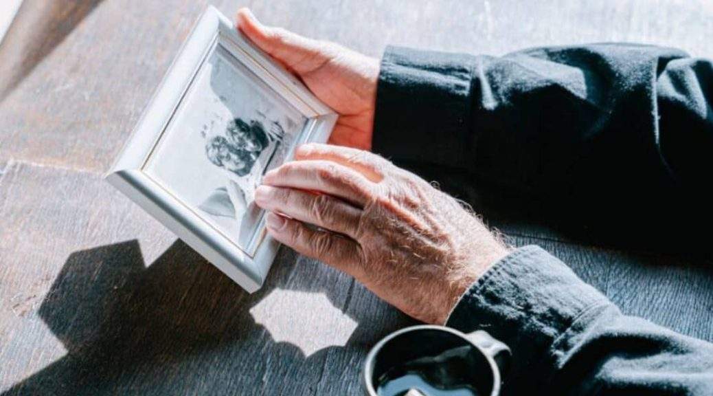 A family member tenderly caressing a photo of a missing loved one, illustrating the emotional journey to locate a person